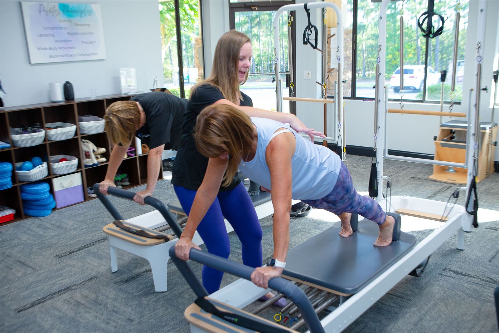 Instructor giving hands-on guidance during a class at Parks Pilates