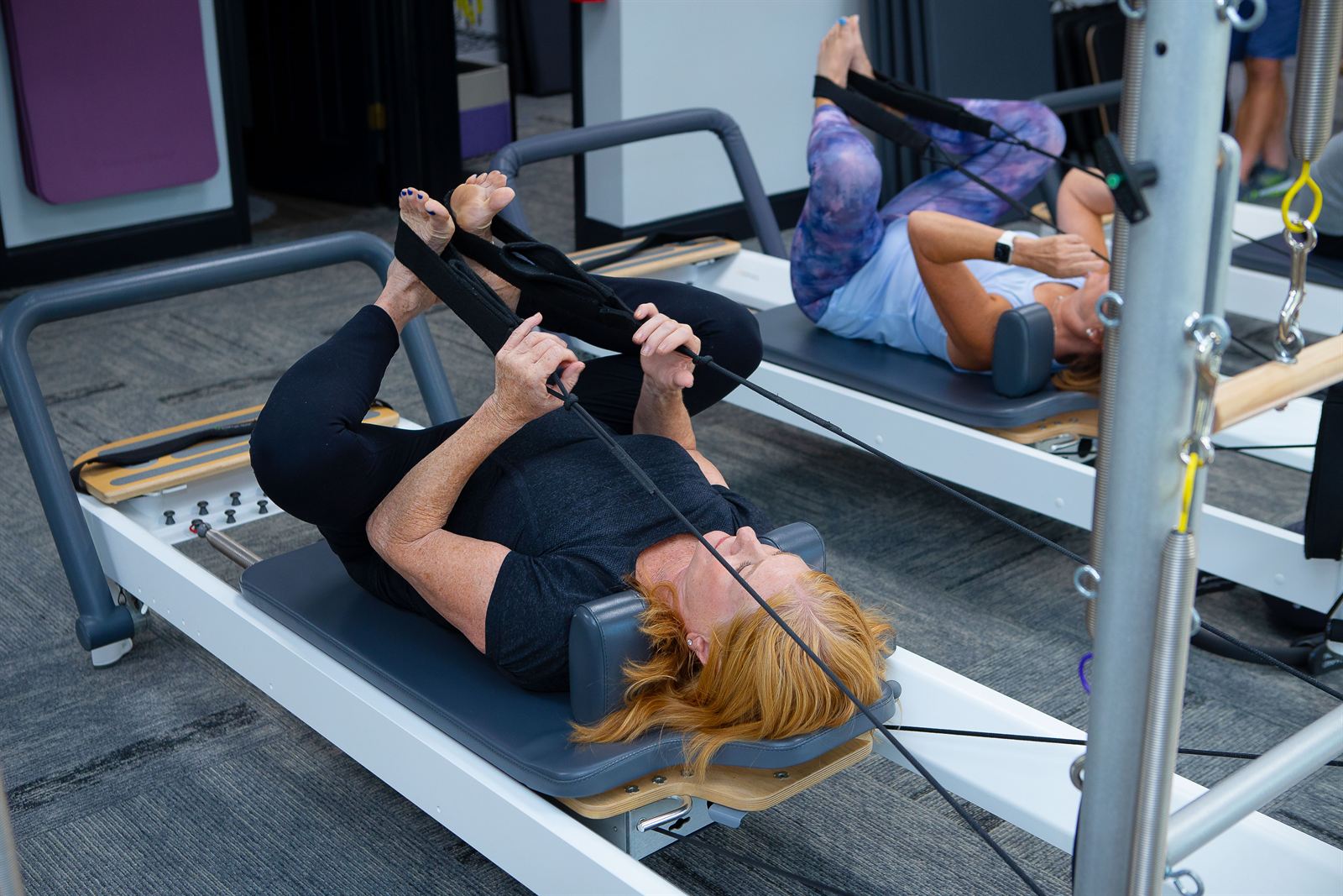 Client stretching on a reformer during class at Parks Pilates